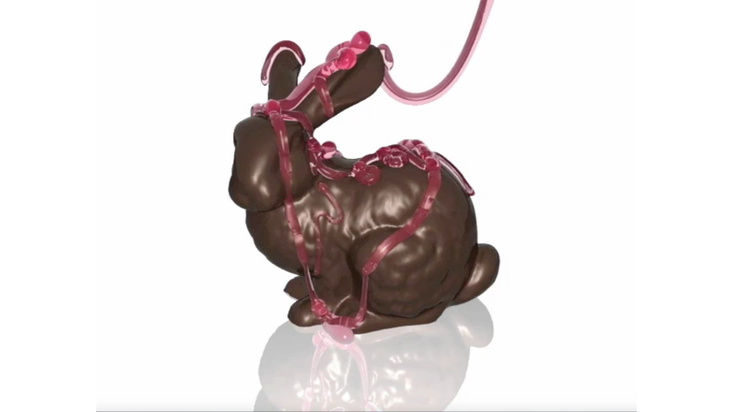 A stream of raspbrerry sauce being poured over a chocolate bunny