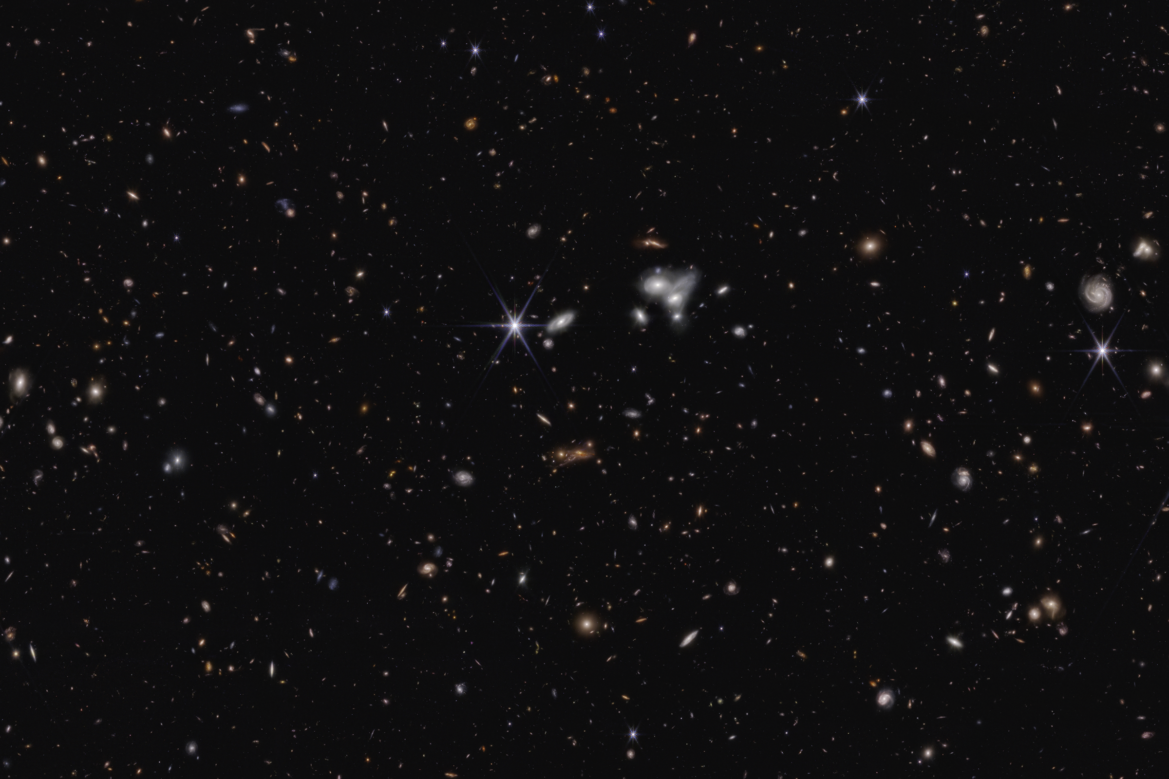 A dense field of galaxies set against a black background of space